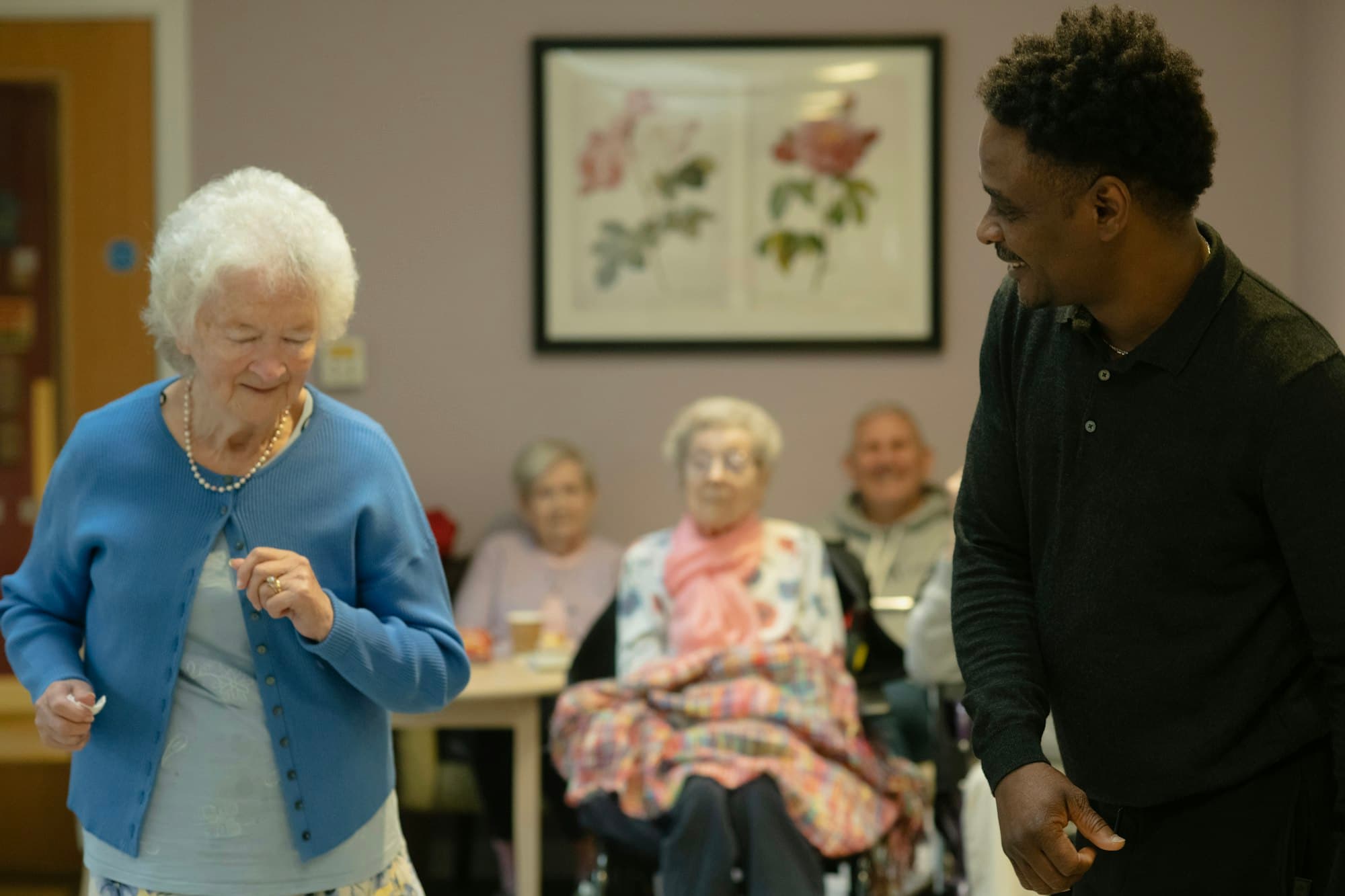 A caregiver and an individual sharing a lively moment during an activity