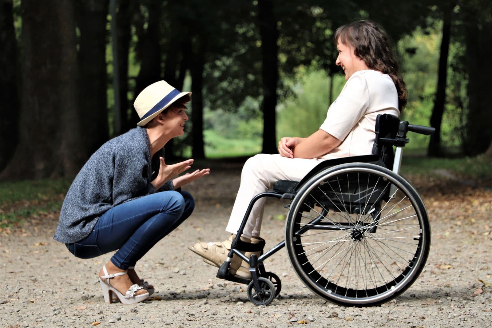 A companion having a warm, supportive conversation with a wheelchair user